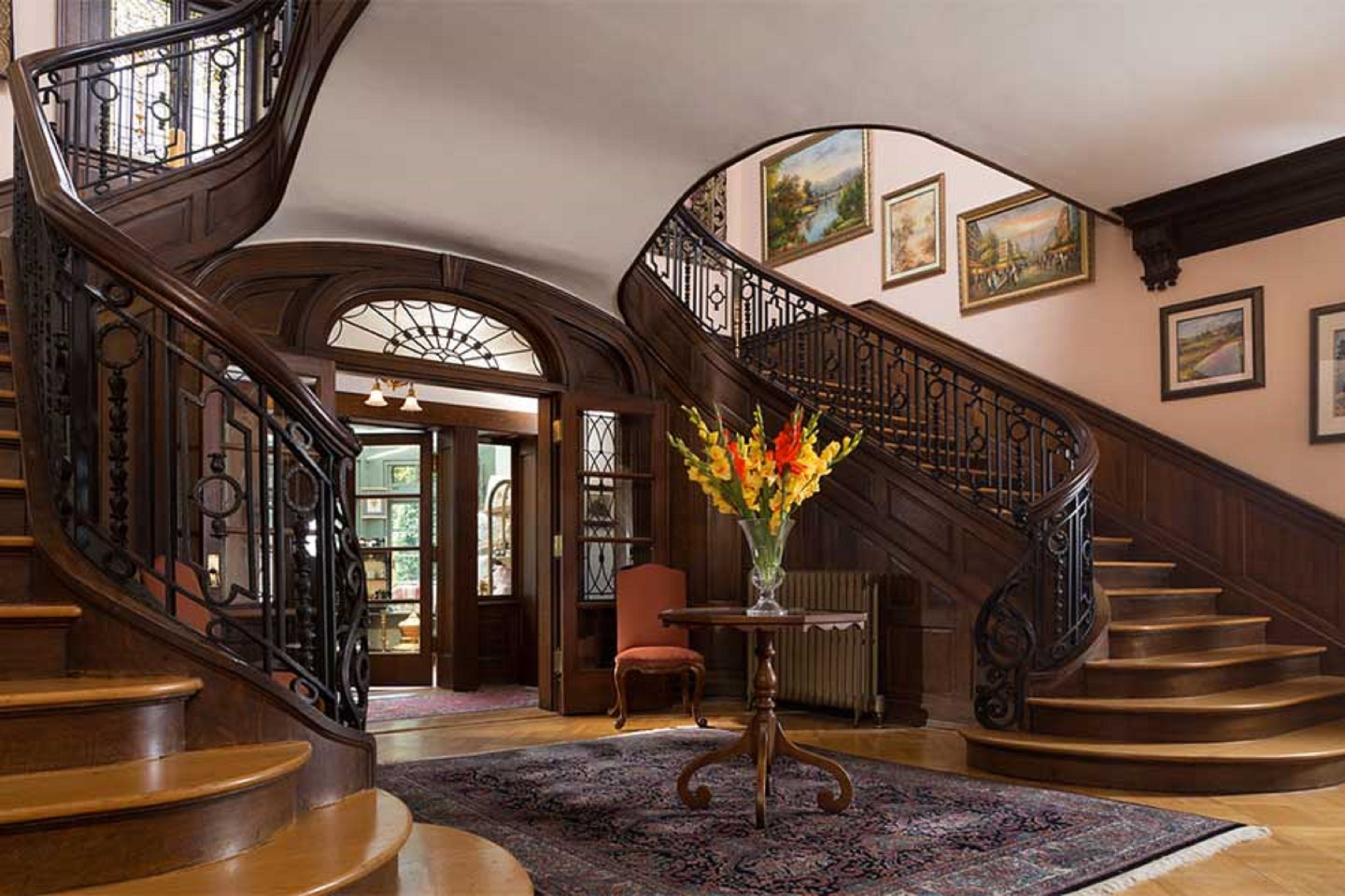 A grand staircase with ornate railings and a floral arrangement in the center.
