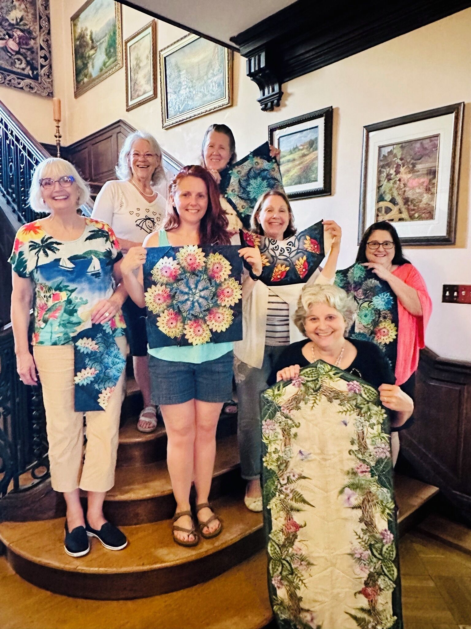 A group of people on a staircase with framed artwork on the walls.
