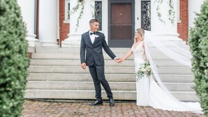 A couple holding hands on a brick staircase with white columns and greenery. - The Mercersburg Inn (Mercersburg)