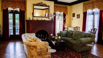 Un salon traditionnel avec une cheminée, deux canapés et un tapis à motifs.