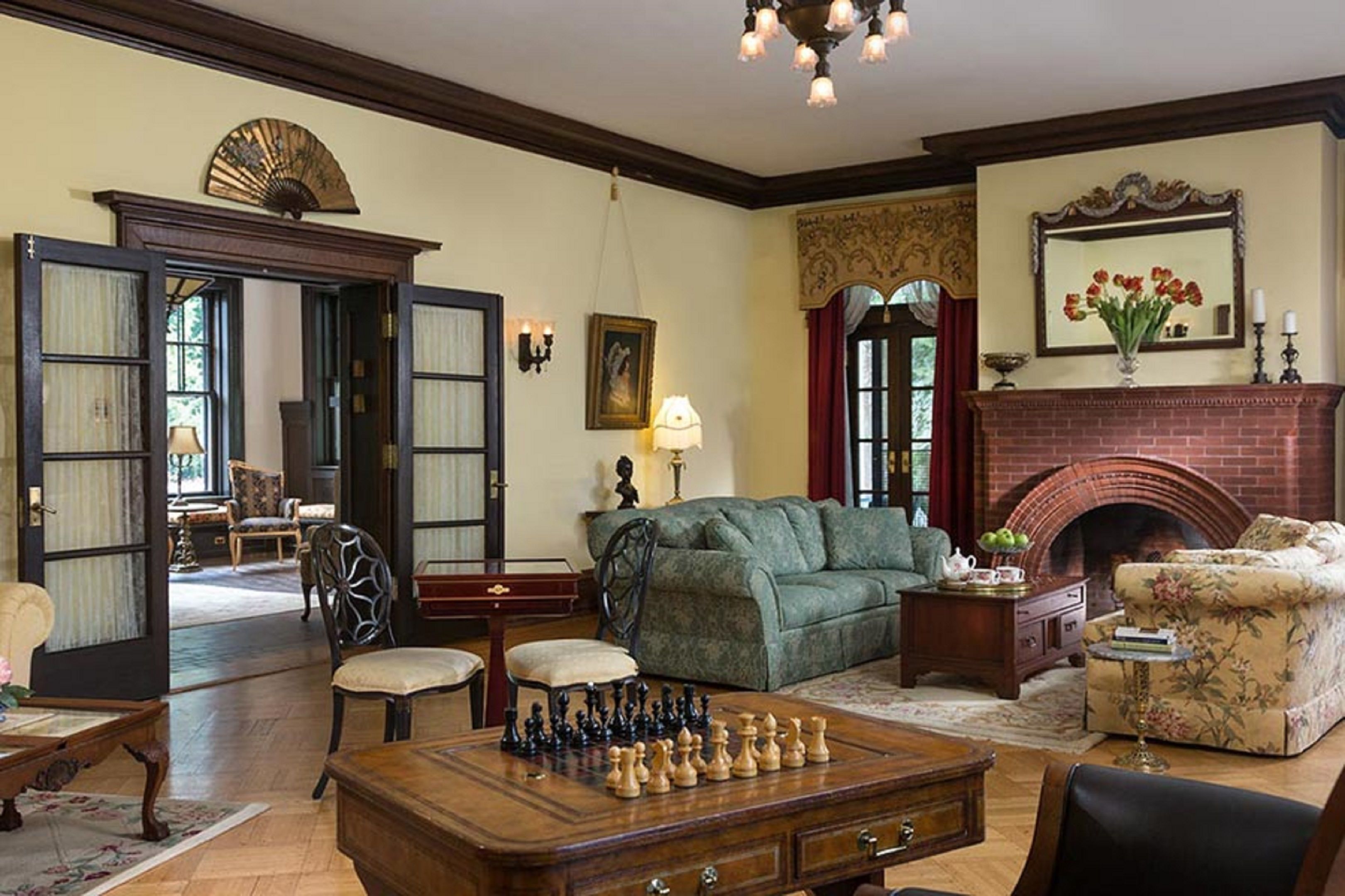 A traditional living room with a fireplace, a chessboard, and classic furniture.