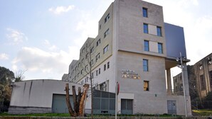 A multi-story building with a flat facade, large windows, and a sign indicating it is a university residence. - Residencia Universitaria Resa As Burgas - Centro Adscrito a REAJ - Campus Accomodation (Ourense)