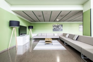 A modern living room with a sofa, a coffee table, and a TV on a stand. - Residencia Universitaria Resa As Burgas - Centro Adscrito a REAJ - Campus Accomodation (Ourense)