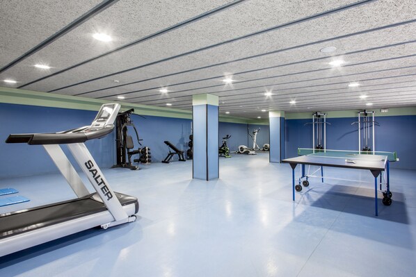 A gym with a treadmill, weights, and a ping pong table. - Residencia Universitaria Resa As Burgas - Centro Adscrito a REAJ - Campus Accomodation (Ourense)