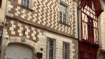 A historic building with a checkered facade, large windows, and a prominent red door.