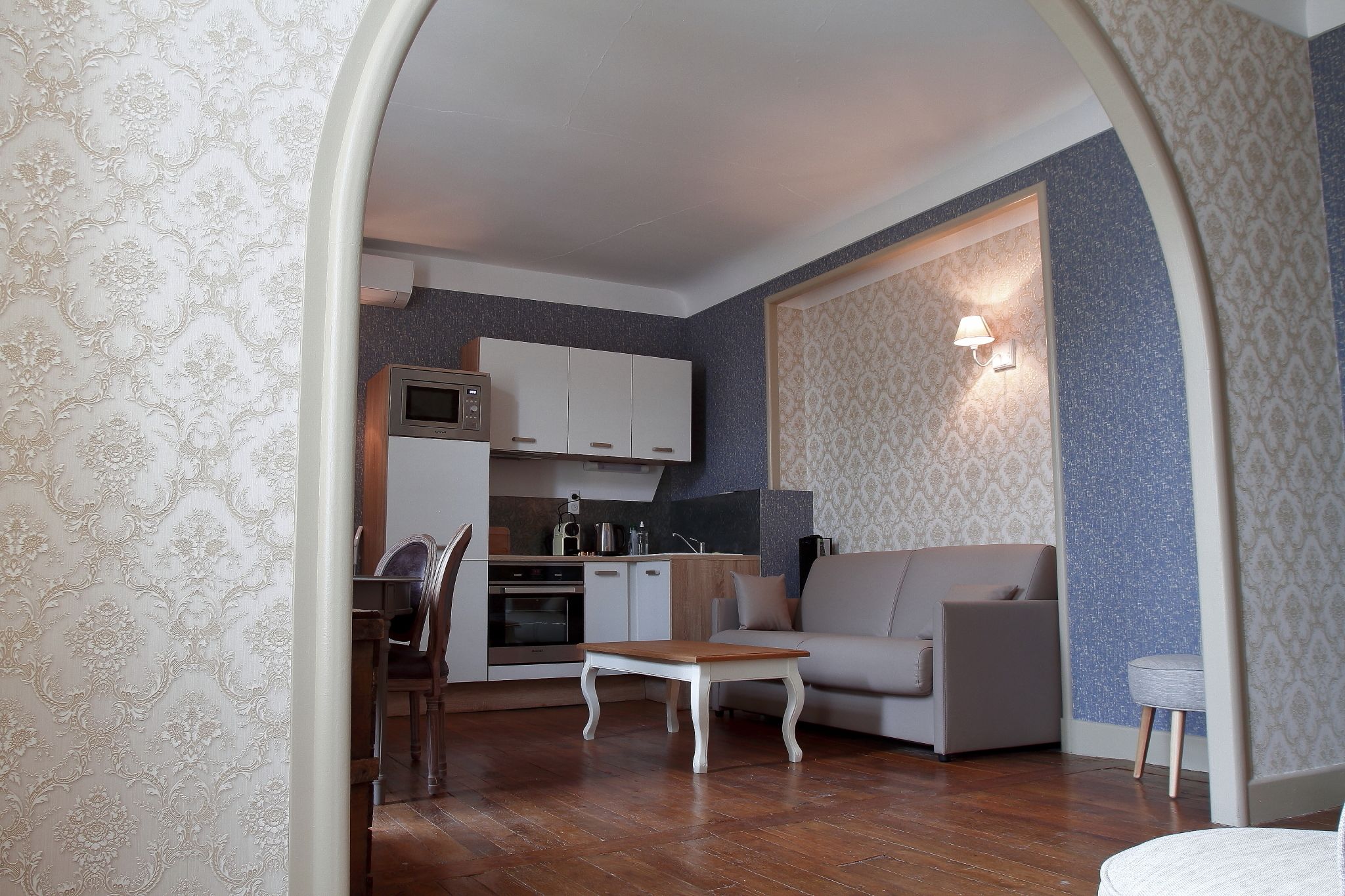 Una sala de estar moderna con un sofá, una mesa de centro de madera y una zona de comedor con sillas y una mesa.