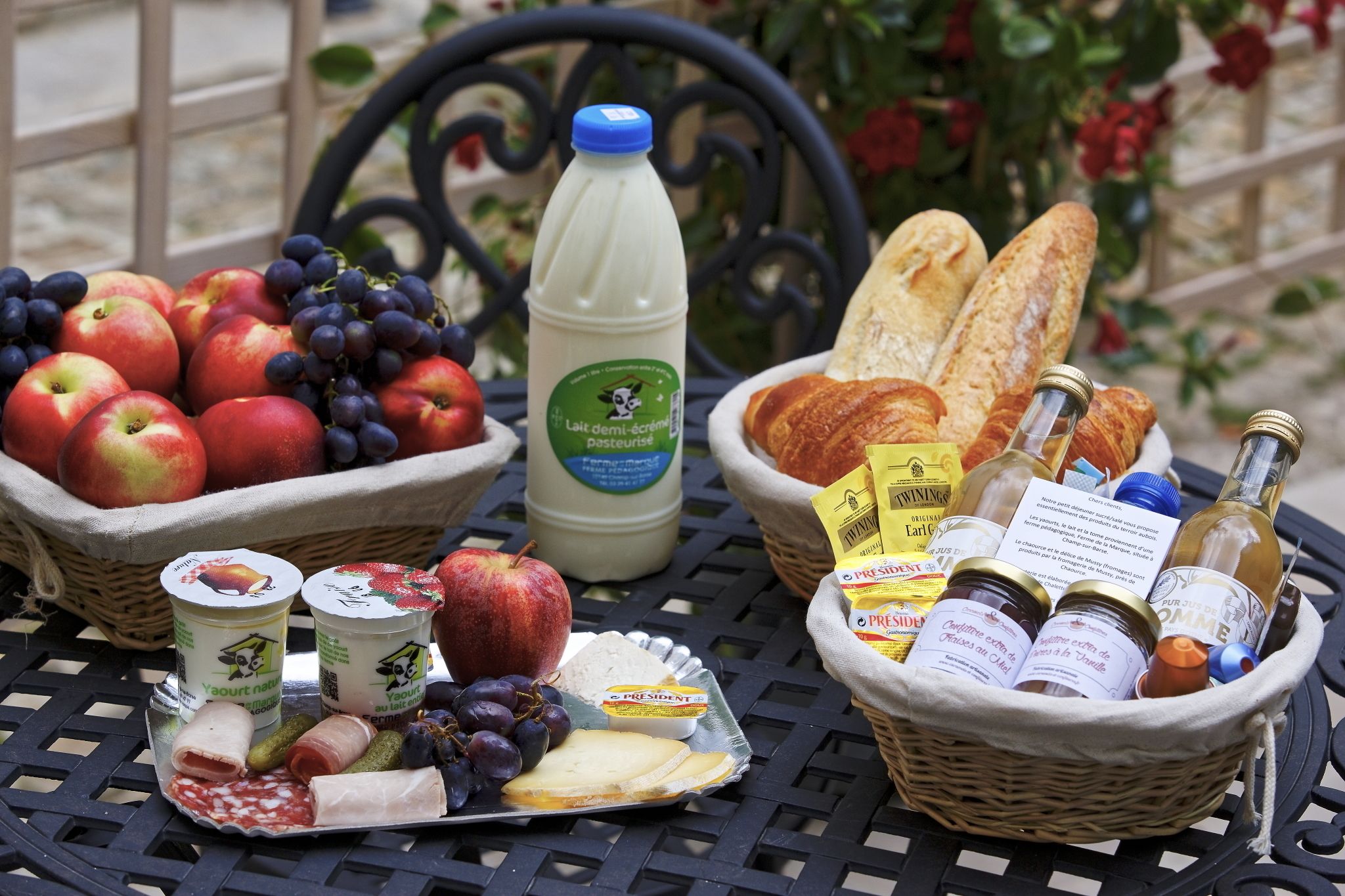 Ein Tisch mit verschiedenen Speisen, darunter Äpfel, Trauben, Käse und Brot.