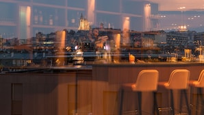 A bar with high stools and a cityscape view in the background. - The Originals Boutique, Hôtel Maison Montmartre Paris Les Puces (Paris)
