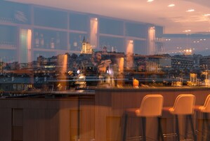 Un bar con taburetes altos y vista panorámica de la ciudad.