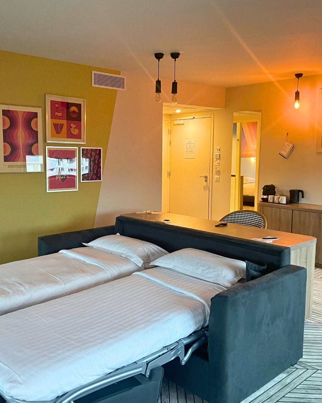 A double bed with a headboard, a bedside table, a mirror, and a small cabinet.