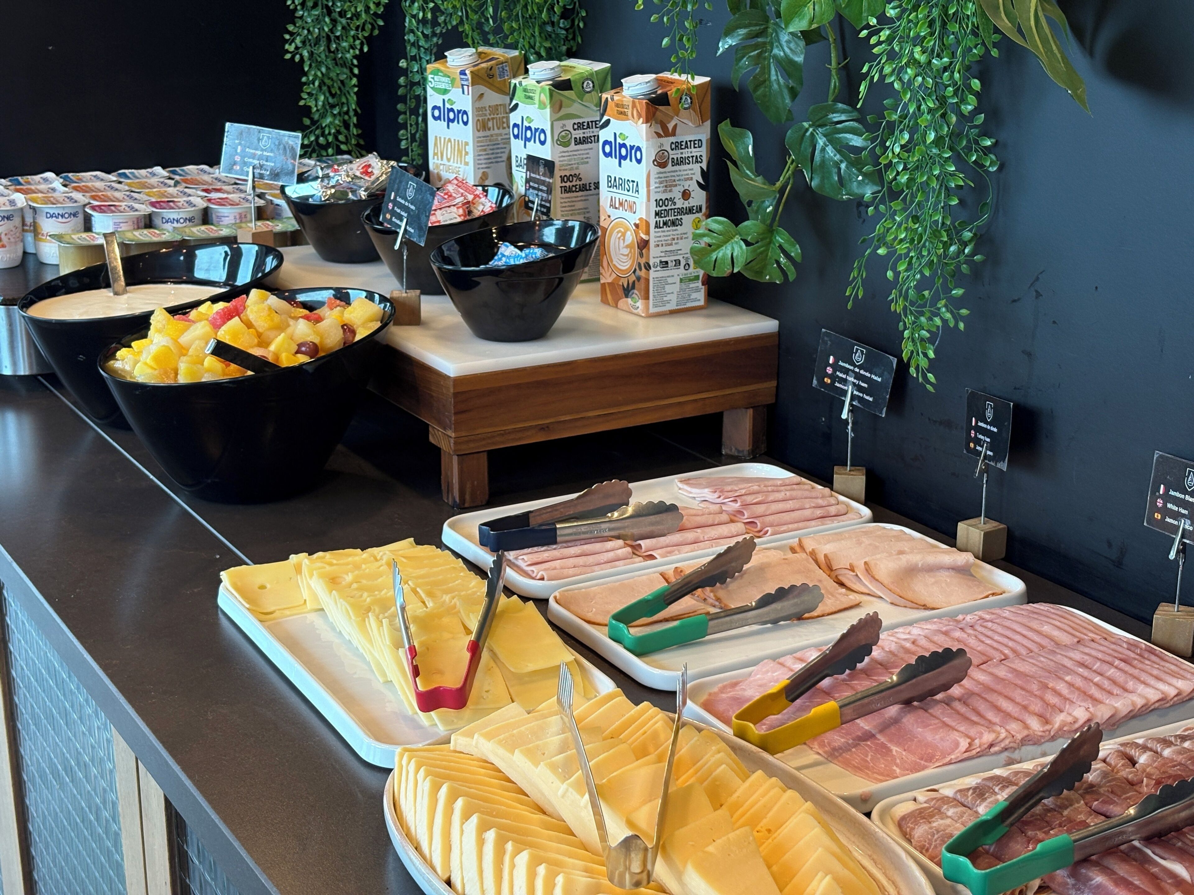 Ein reichhaltiges Buffet mit verschiedenen Speisen, darunter Früchte, Käse und Fleisch.
