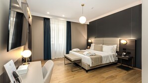 A modern hotel room with a bed, bedside tables, a desk, and a TV. - Hotel San Remo (Rome)