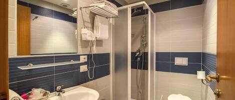 Un baño moderno con ducha, lavamanos e inodoro.