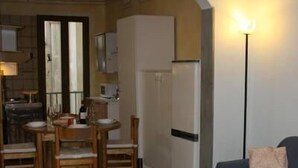 A compact living space with a dining area, kitchenette, and a sofa. - Macci Art (Florence)