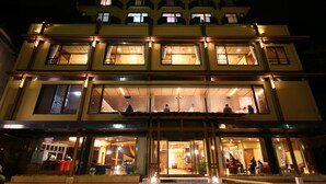 A multi-story hotel with illuminated windows and a well-lit entrance. - Fuji Ginkei (Fujikawaguchiko)