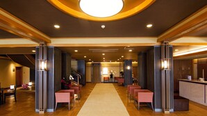 A spacious lobby with a central carpeted walkway, wooden flooring, and modern lighting fixtures. - Fuji Ginkei (Fujikawaguchiko)