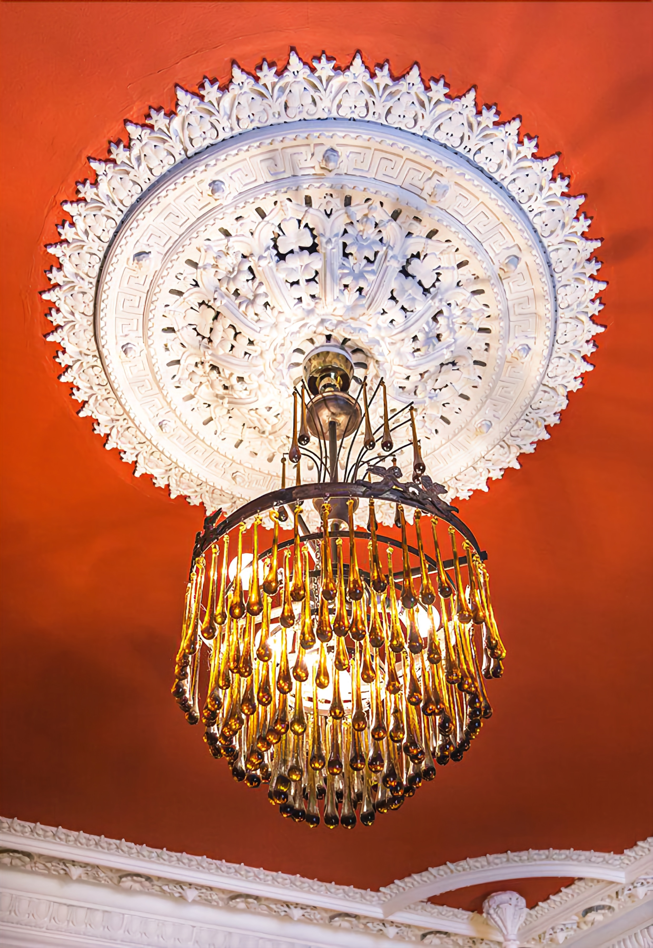 Un candelabro con diseño circular y una moldura en el techo.