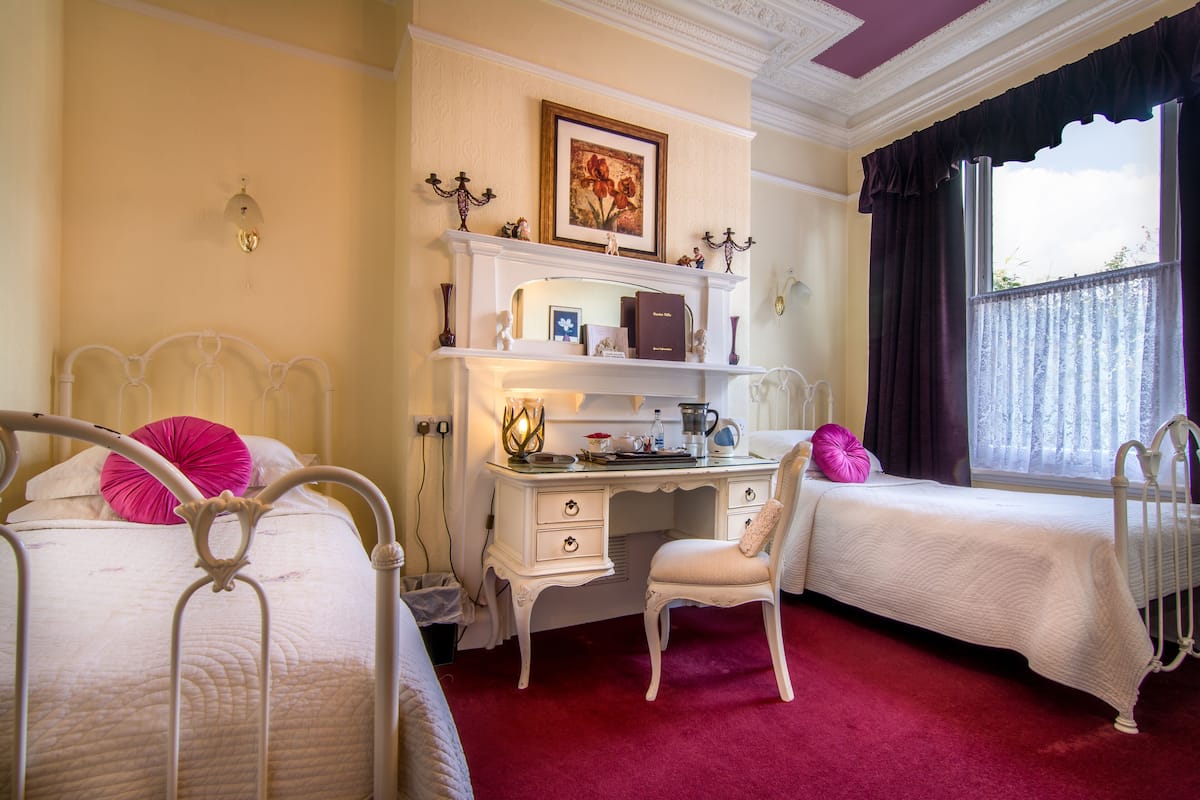 Une chambre avec deux lits, un bureau et une chaise.