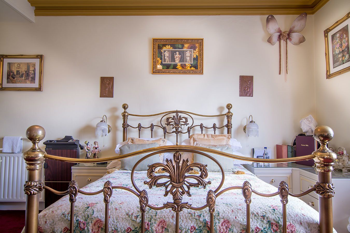 Ein Schlafzimmer mit einem klassischen Himmelbett, einem Heizkörper, einer Kommode und einer Wandlampe.