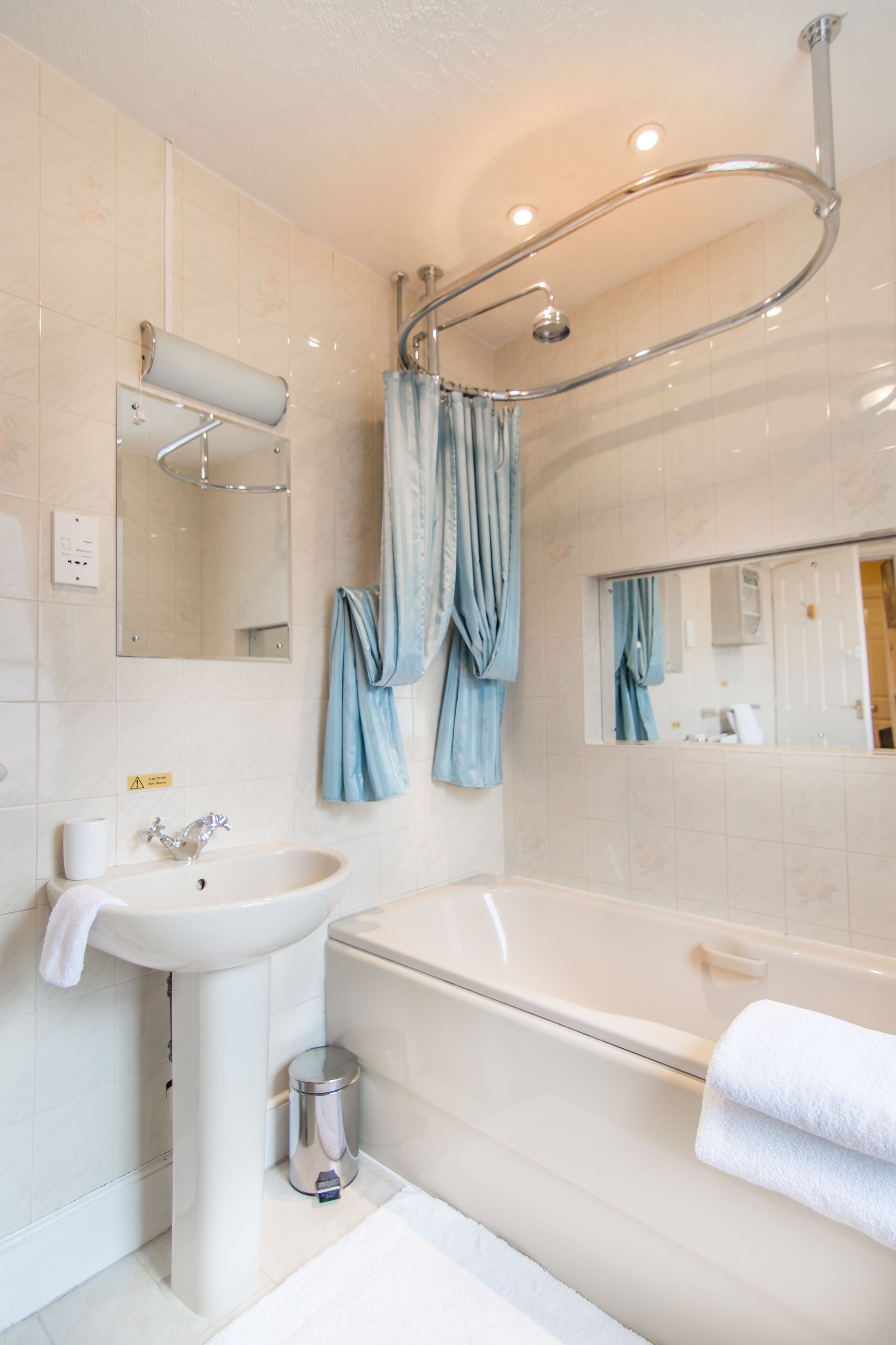A modern bathroom with a sink, bathtub, and a shower with a glass door.
