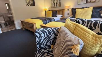 A bedroom with a zebra-themed bedspread, multiple pillows, and artwork on the walls.