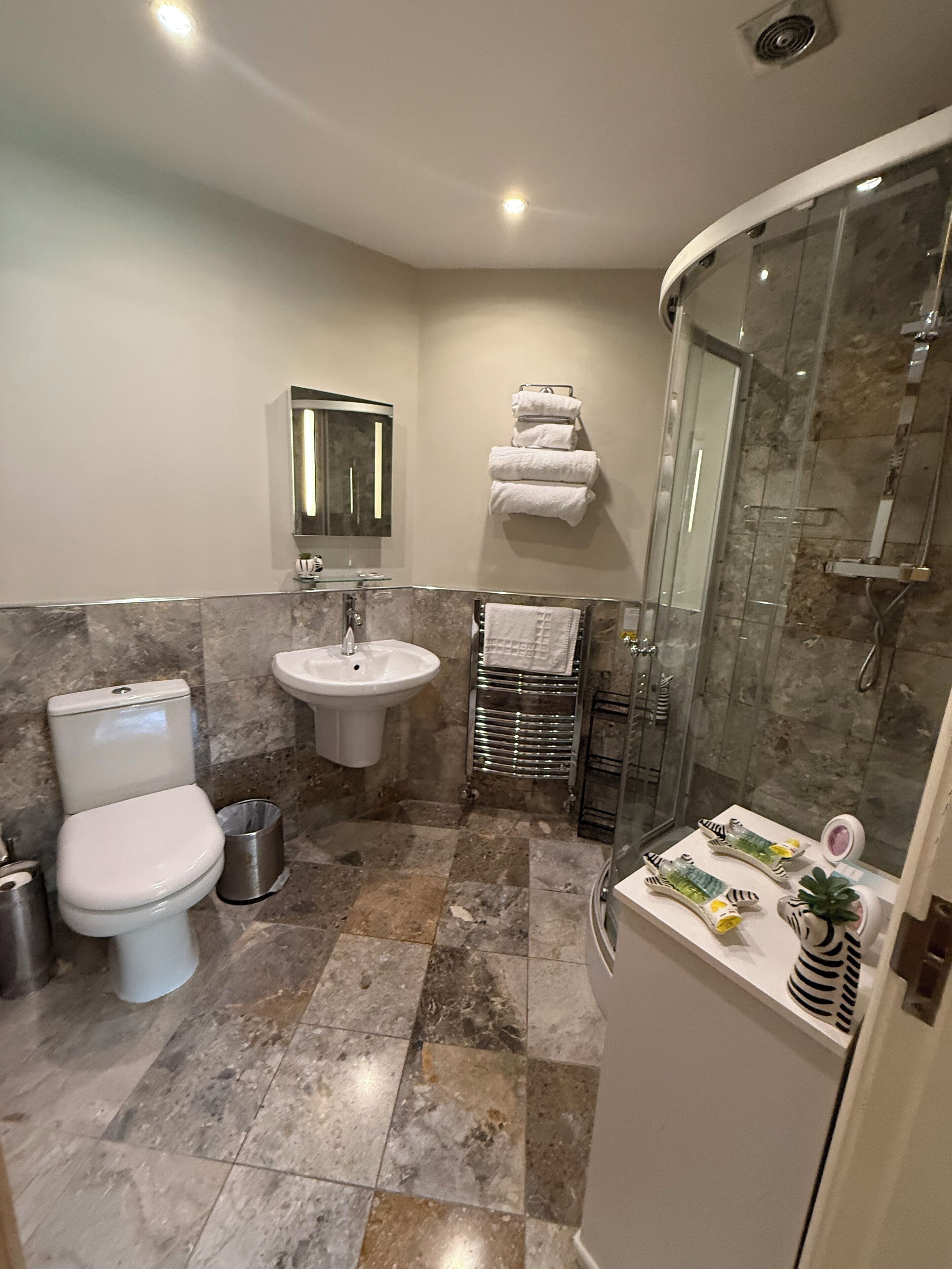 A bathroom with a toilet, sink, and shower.