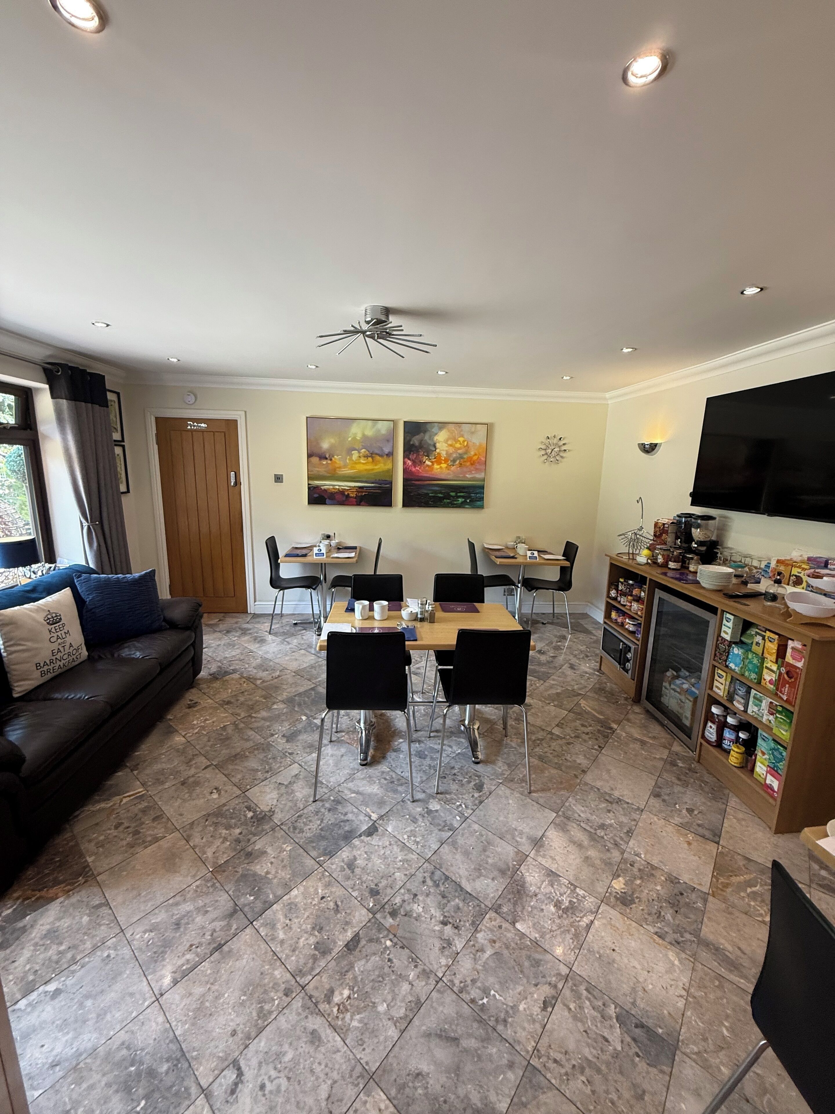 A modern living room with a dining area, featuring a sofa, a coffee table, and a TV.