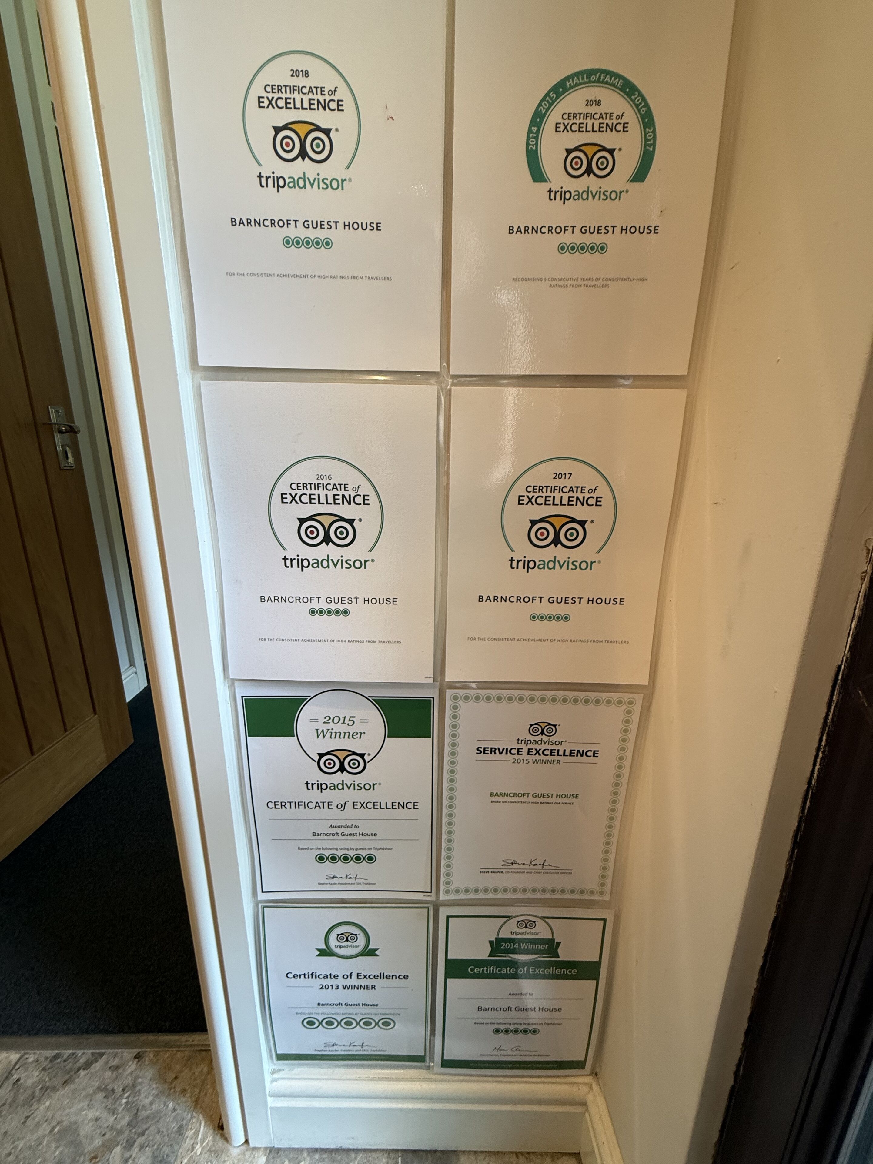 En væg med flere TripAdvisor-diplomer for udmærkelse for Barncroft Guest House fra 2013 til 2018.