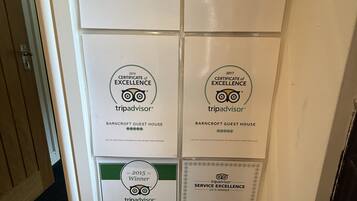 En væg med flere TripAdvisor-diplomer for udmærkelse for Barncroft Guest House fra 2013 til 2018.