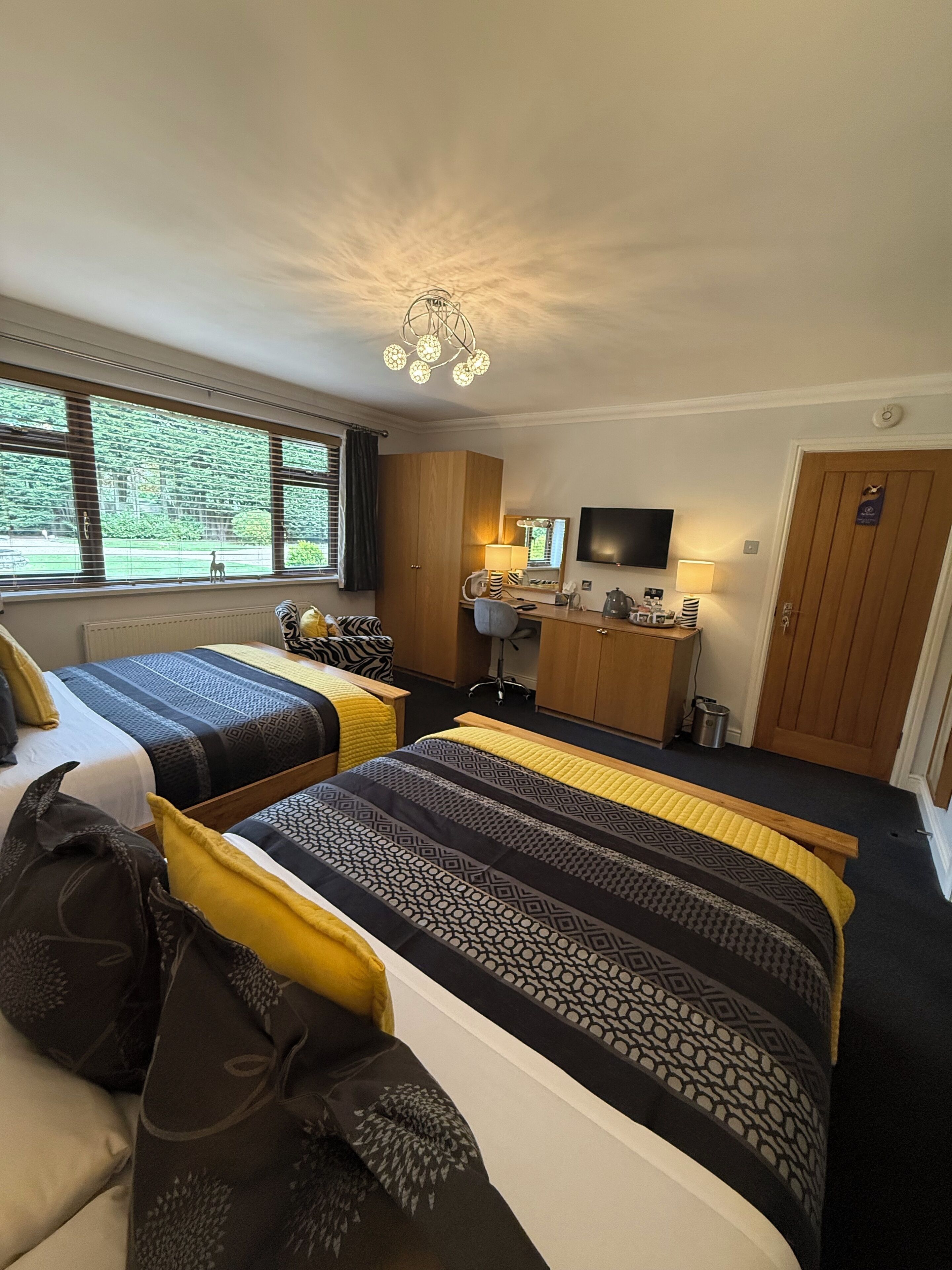 Une chambre d’hôtel avec deux lits, un bureau, une télévision et une vue sur l’extérieur.