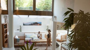 A spacious living area with a sofa, a coffee table, and a bookshelf. - Hotel el Petit Convent (Begur)