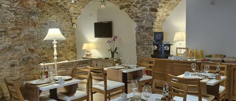 Un ristorante con pareti in pietra, arredi in legno e un design moderno.