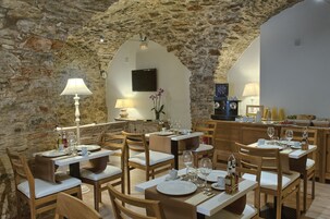 A restaurant with stone walls, wooden furniture, and a modern interior design.