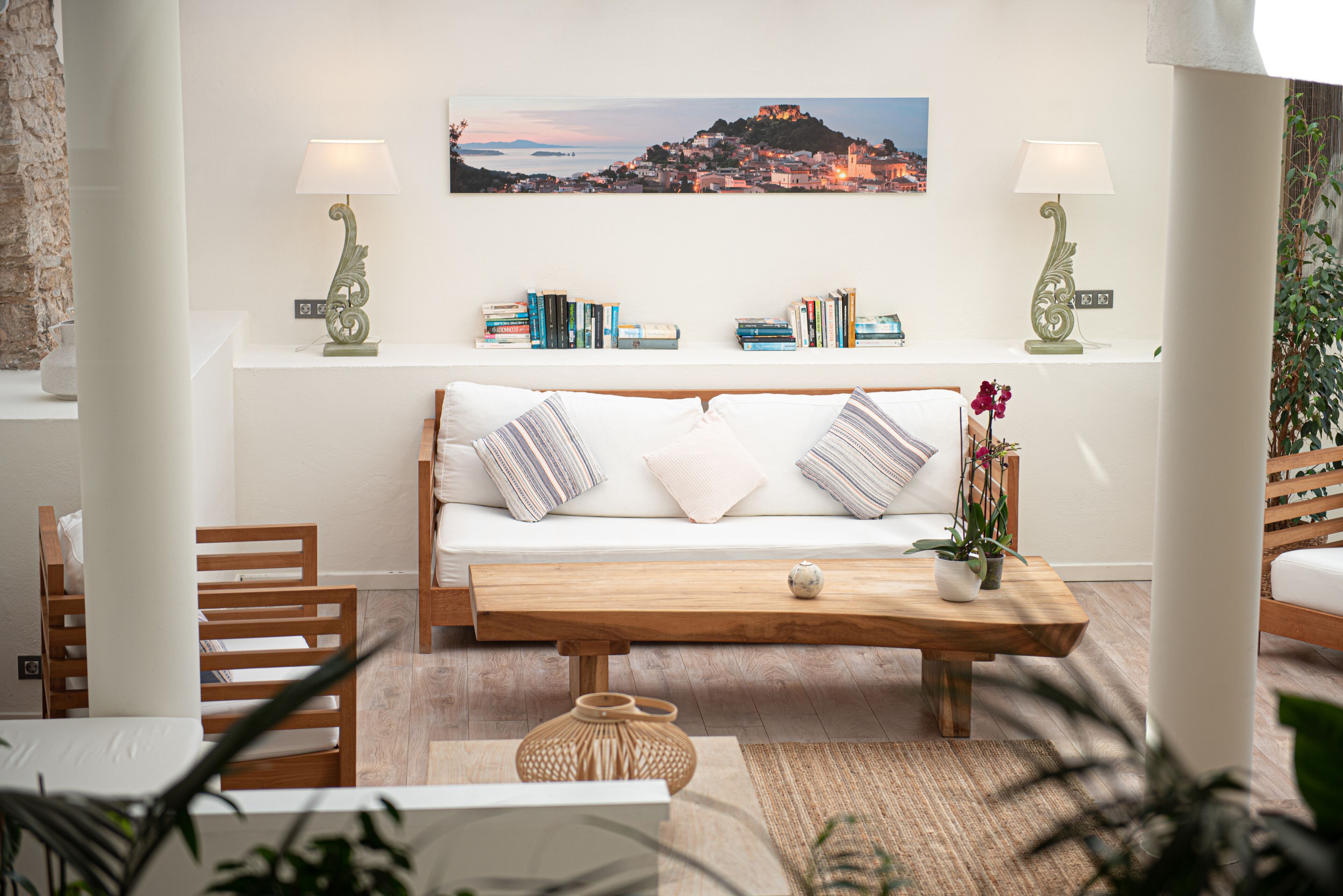 A cozy living room with a wooden sofa, a coffee table, and a bookshelf with books.