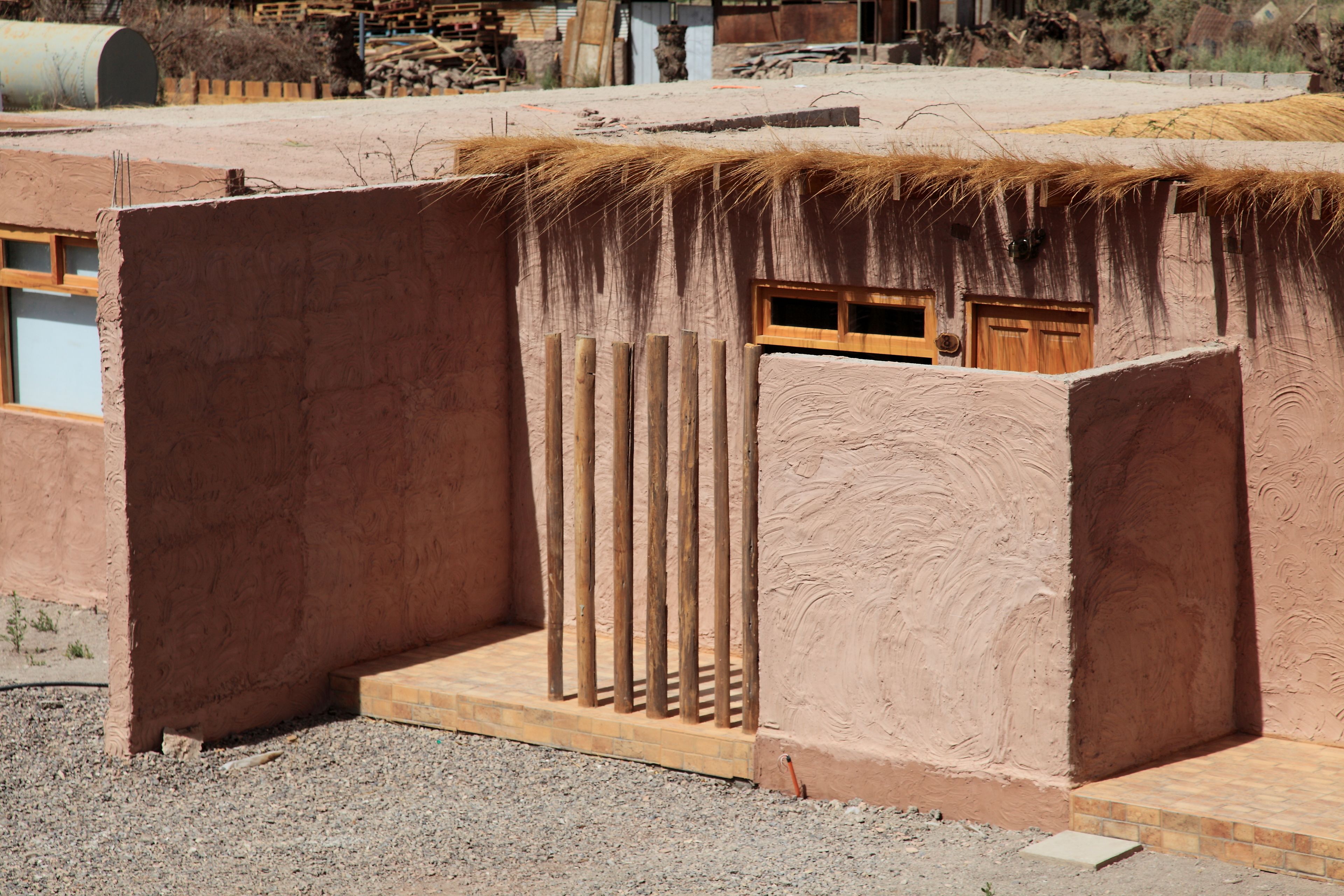 A building with a unique architectural design, featuring a thatched roof and a wooden door.
