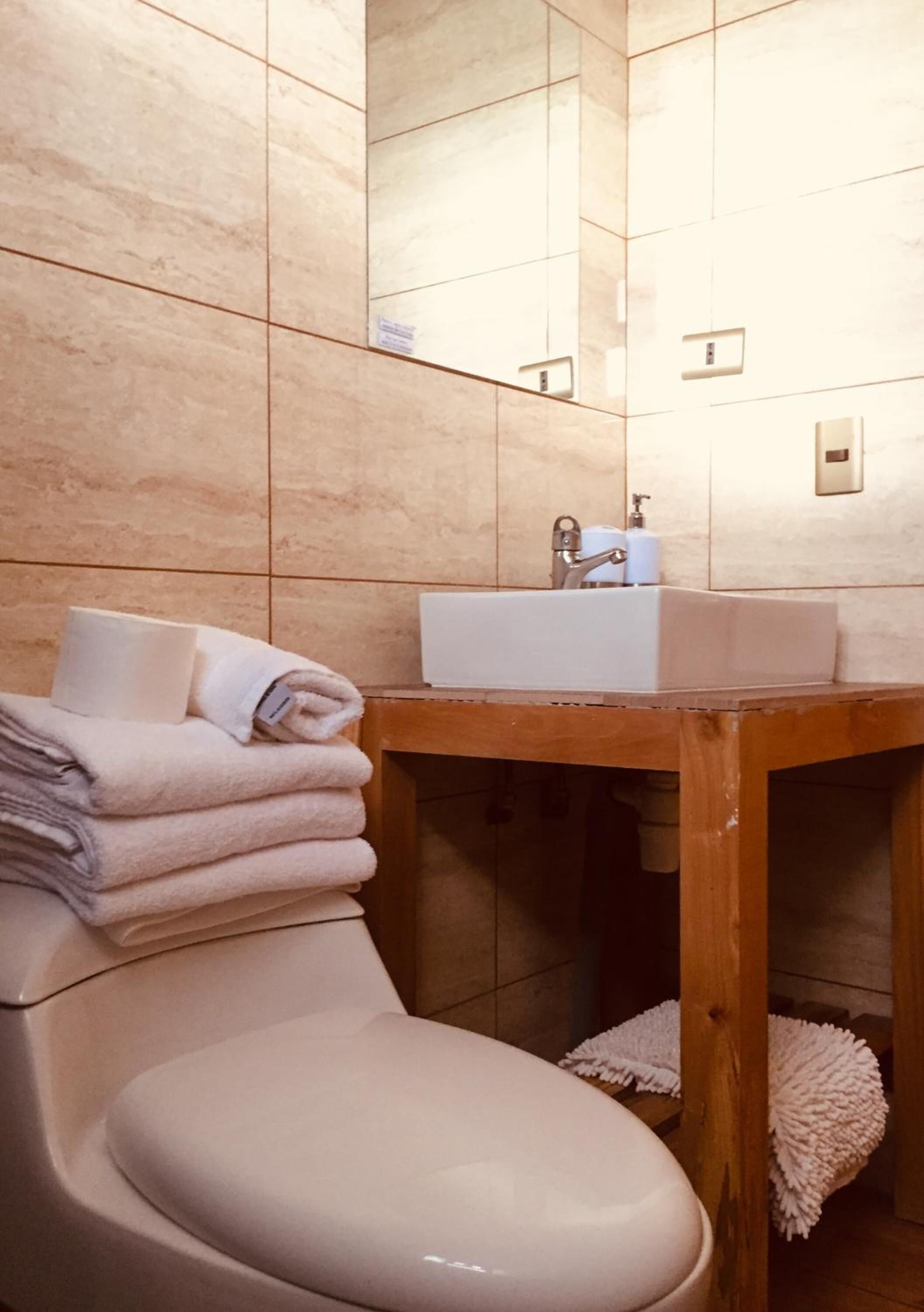 A bathroom with a toilet, a sink, and a mirror.