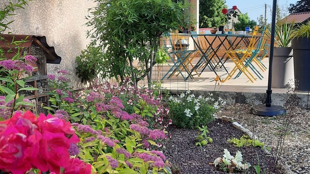 A garden with vibrant flowers and a patio area with outdoor furniture. - Le Pont de la Loire (Bourbon-Lancy)