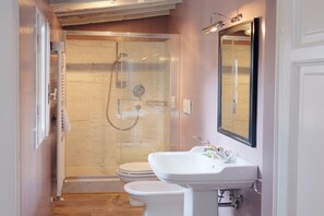 A modern bathroom with a glass-enclosed shower, a white sink, and a toilet. - Vivaldi Terrace (Florence)