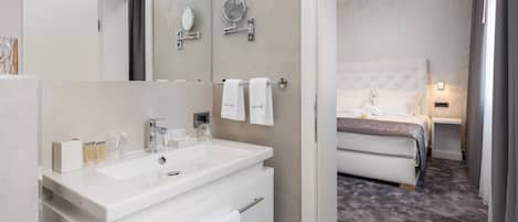 Een moderne badkamer met een grote spiegel, een witte wastafel en een badkamermeubel.