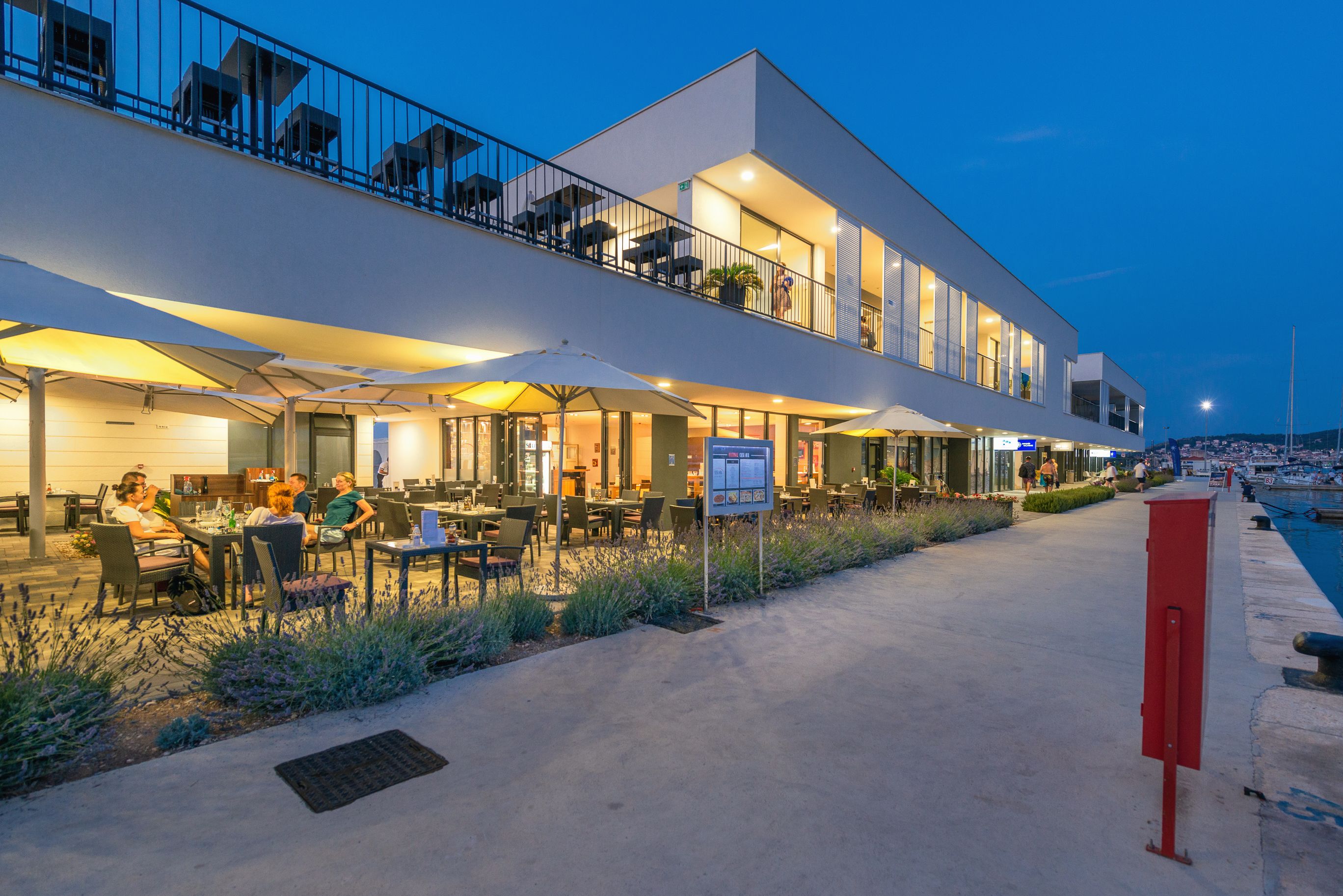 A modern hotel with outdoor seating and a poolside area.