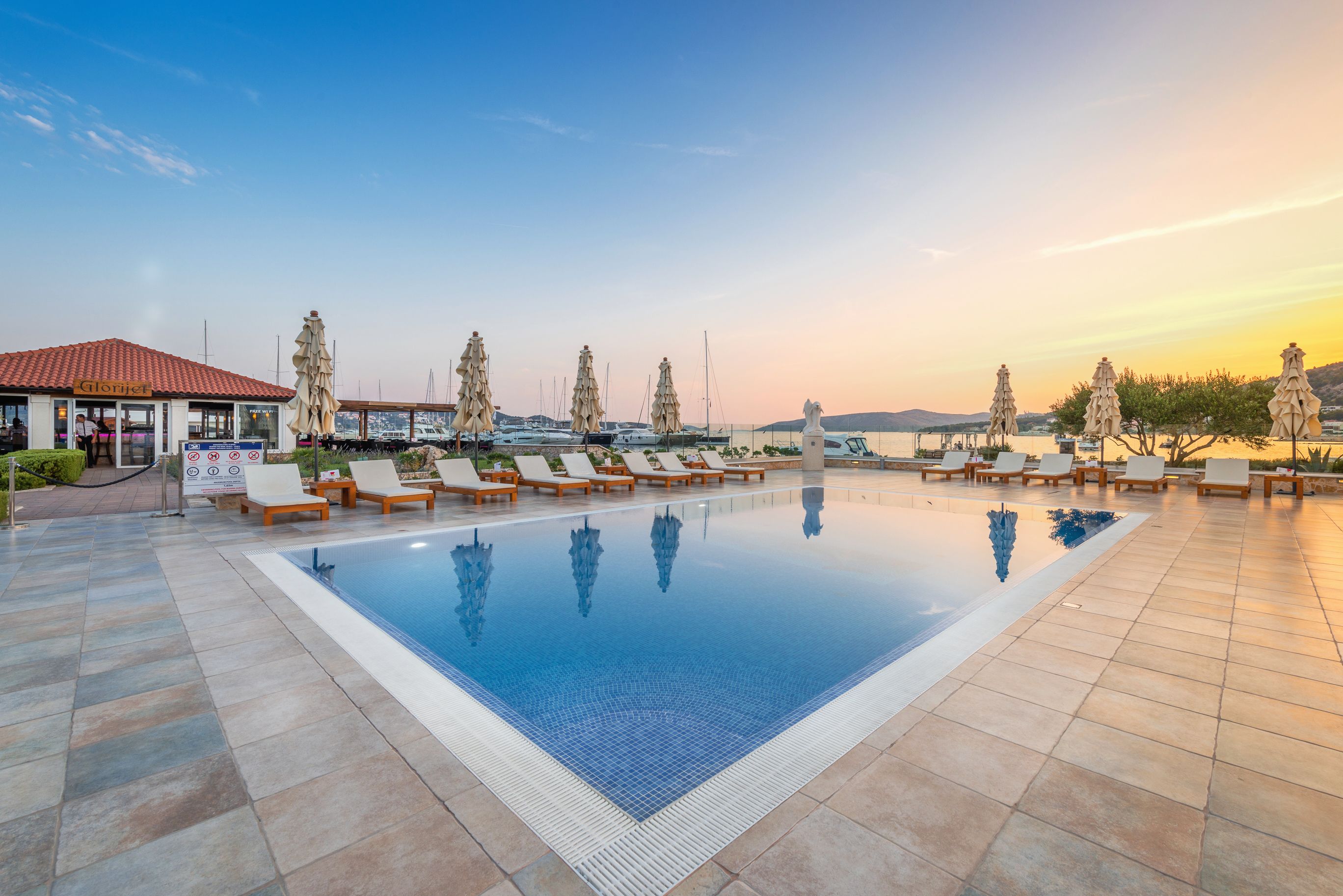 seasonal outdoor pool, open 9:00 am to 7:00 pm, pool umbrellas