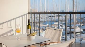 Un balcon avec une table, une bouteille de vin et un verre de vin.