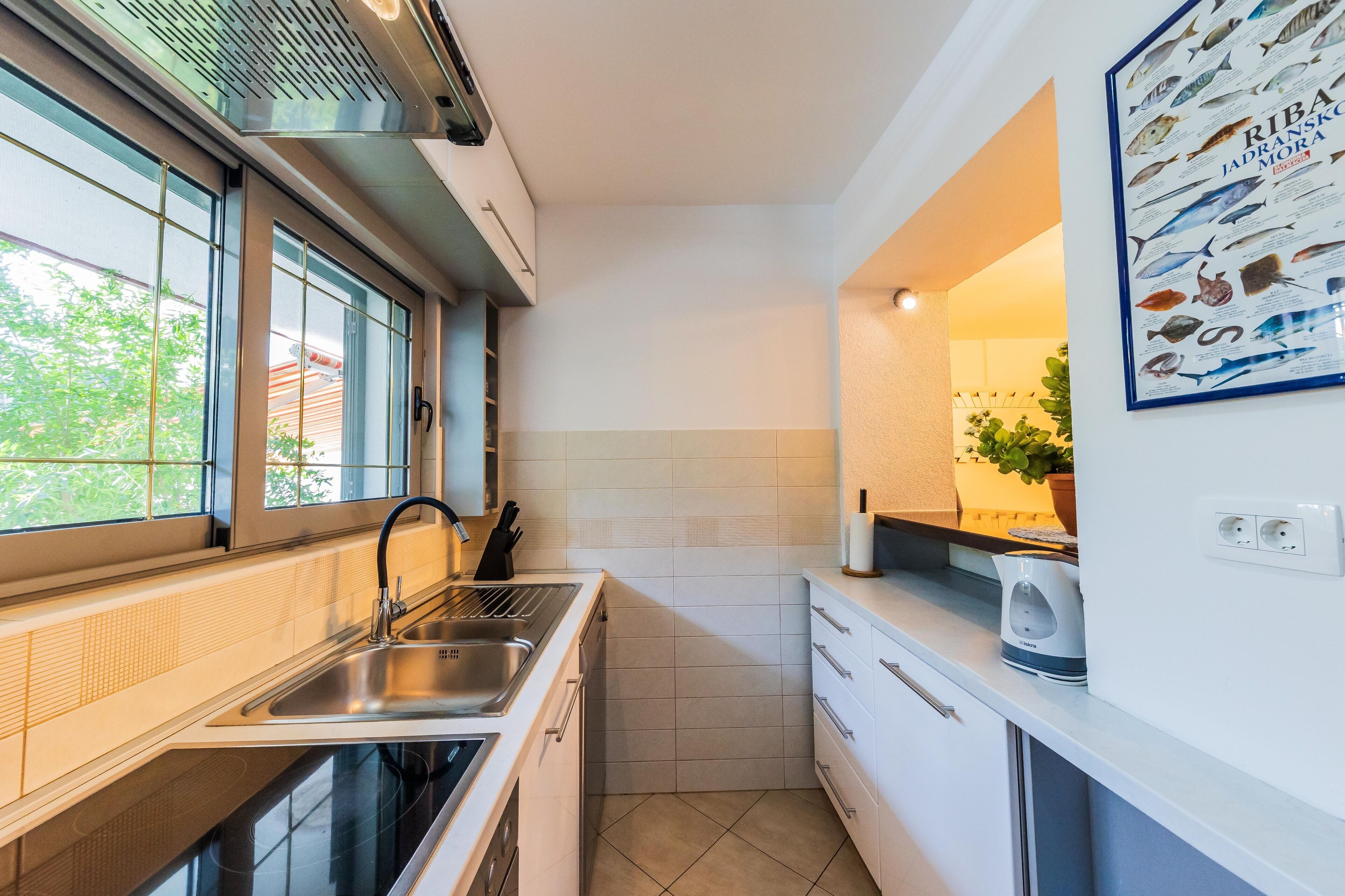 Una cocina moderna con un lavamanos, estufa y ventana.