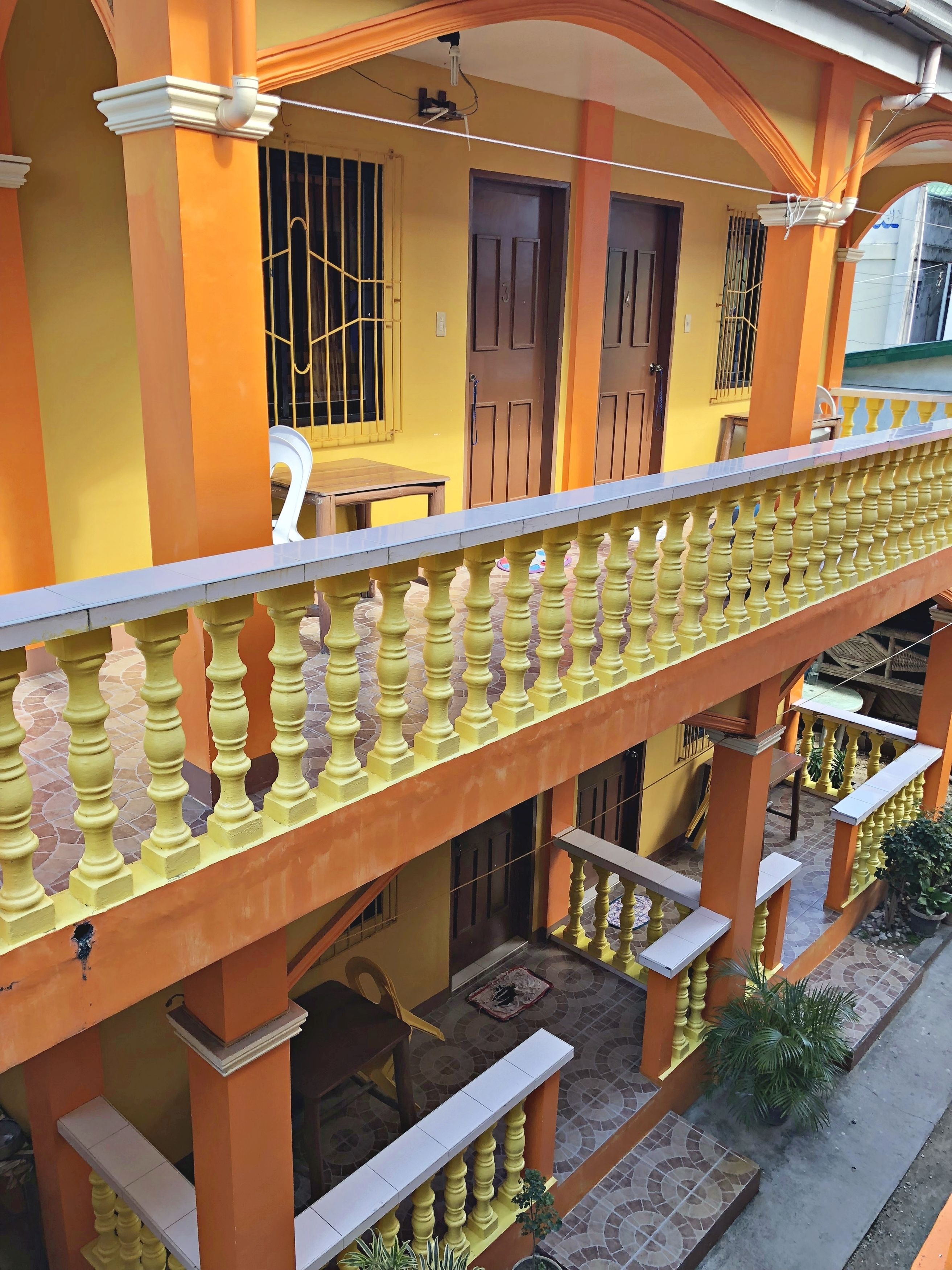 A yellow building with a balcony featuring a balustrade.