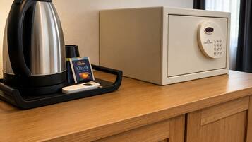 Et hotelværelse med kaffemaskine, bakke med kaffekop og menu samt minibar.