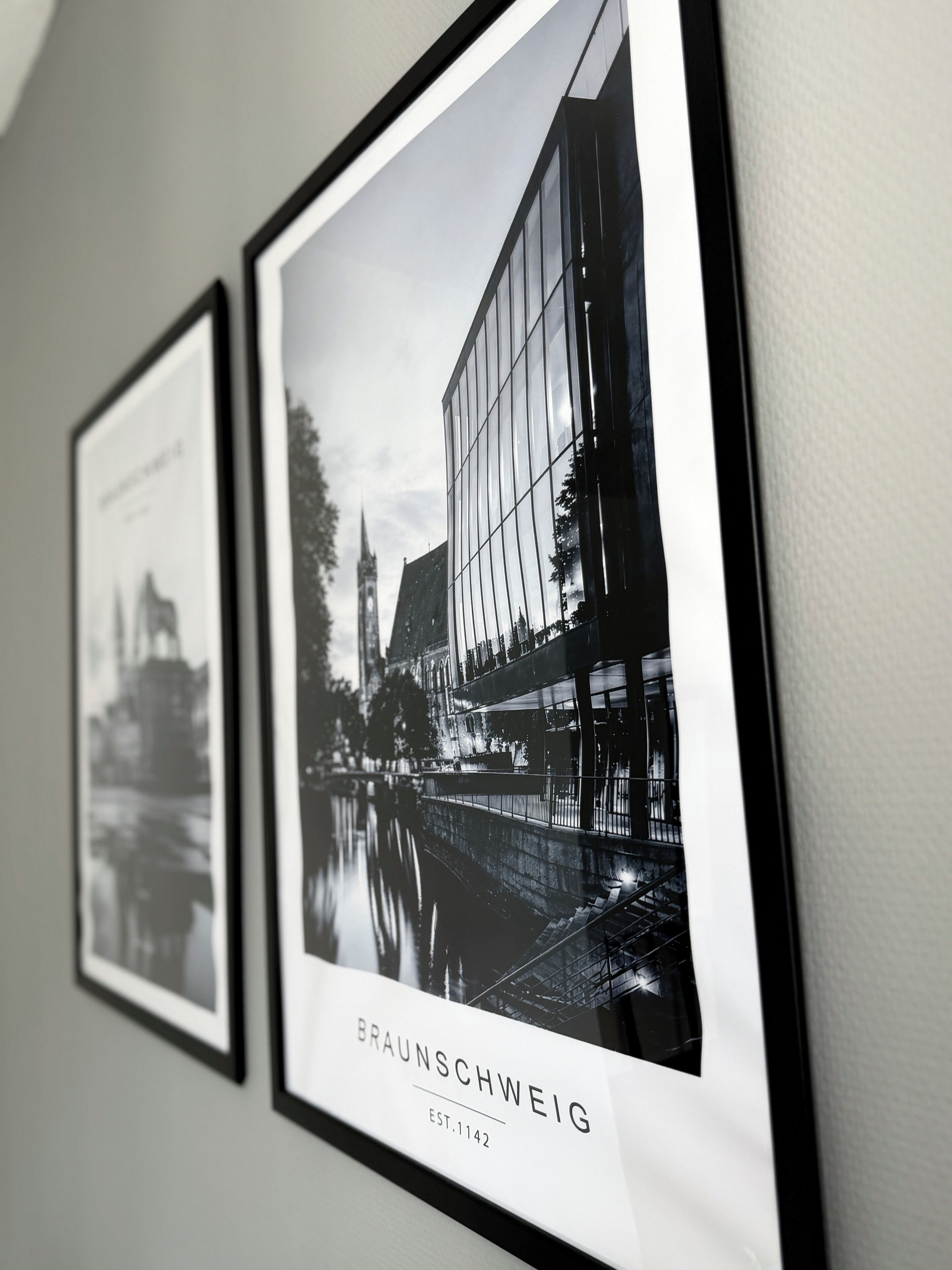 Two framed black and white photographs of a building with the text 'BRAUNSCHWEIG EST.1142' below them.