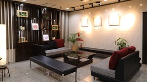 Un vestíbulo moderno con un sofá, bancos y una mesa de centro.