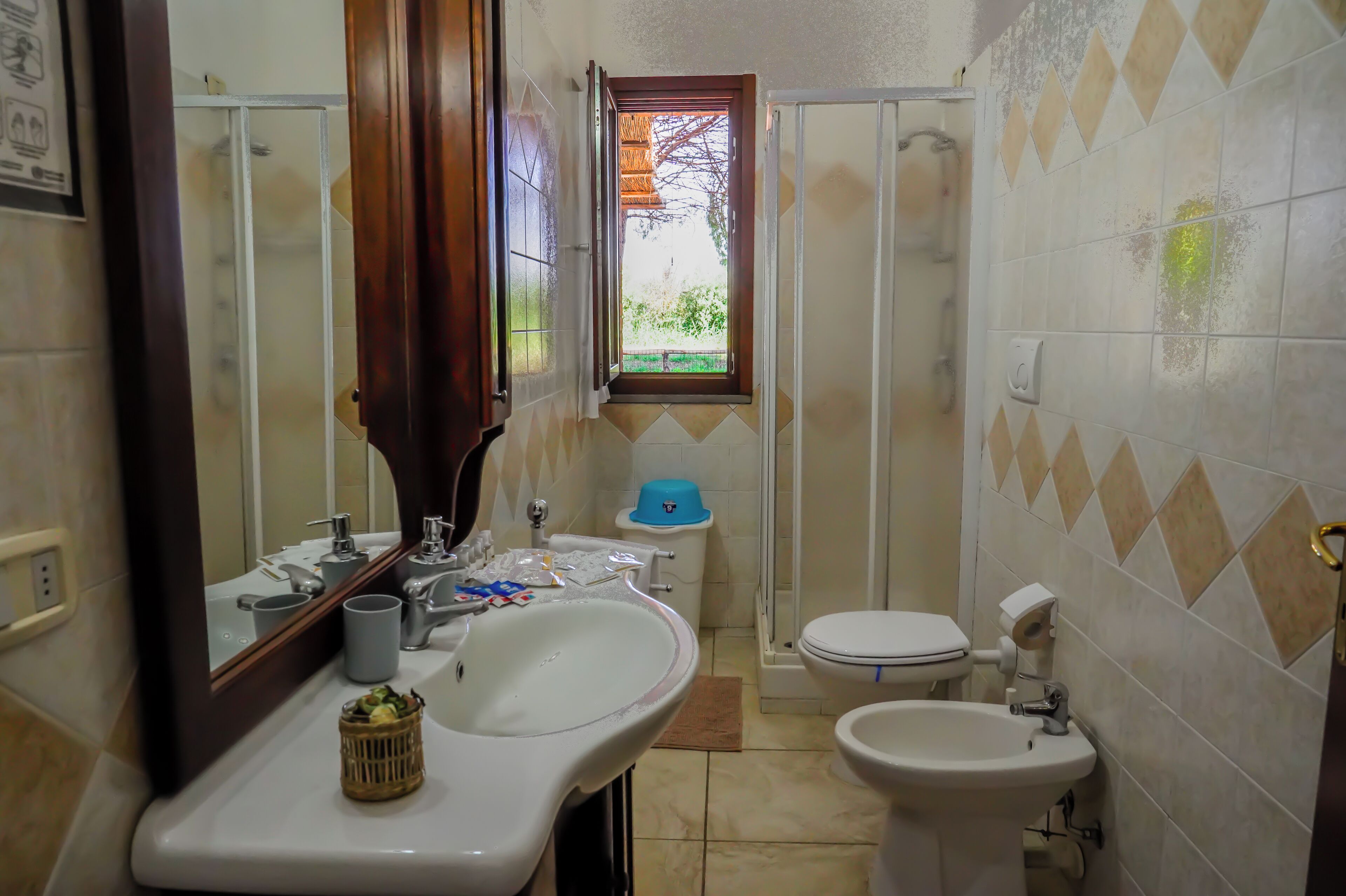 A bathroom with a sink, mirror, toilet, and shower.