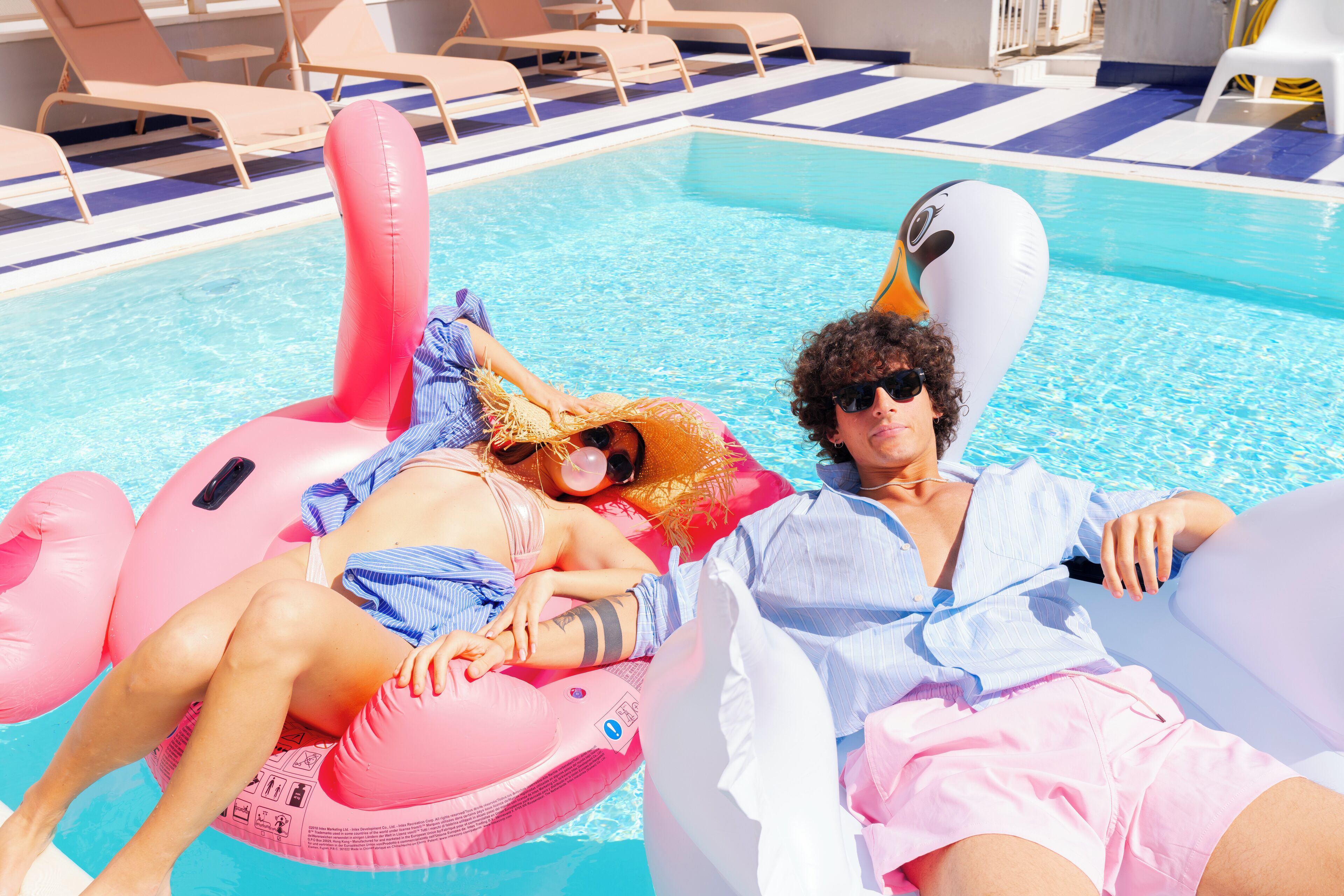 A pool area with lounge chairs and inflatable floats.