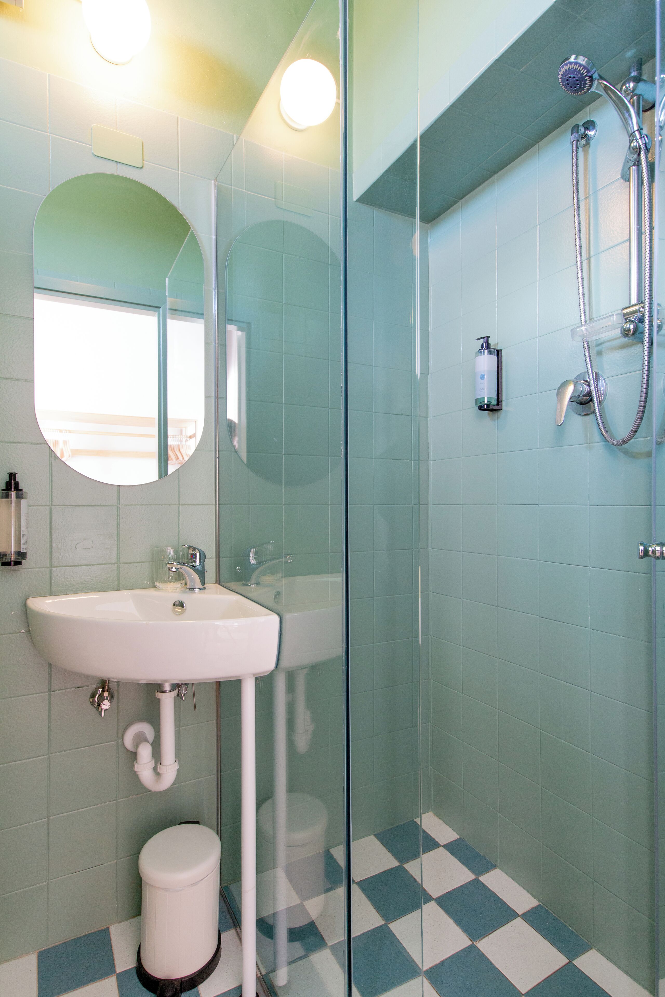 Un bagno con lavandino, specchio e doccia.